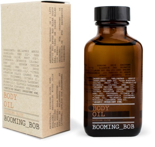 Brązowa butelka z etikietą 'Body Oil' i czarnym zamknięciem, obok beżowe pudełko z listą składników.