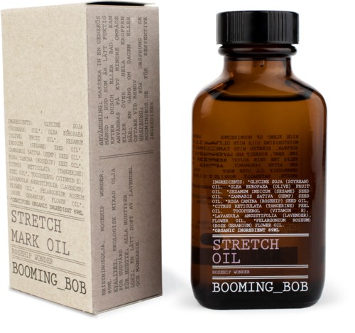 Een kleine amberkleurige fles met label 'Stretch Oil' en 'Booming Bob' naast een wit doosje met tekst.