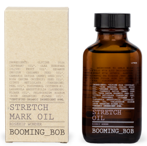 Een bruin flesje en een crèmekleurige doos bevatten Stretch Mark Oil met rozenbottel en andere natuurlijke ingrediënten.