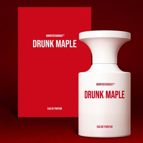 Valkoinen hajuvesi pullo, jonka punainen teksti lukee "Drunk Maple" ja vieressä oleva punainen paketti, taustalla punainen.
