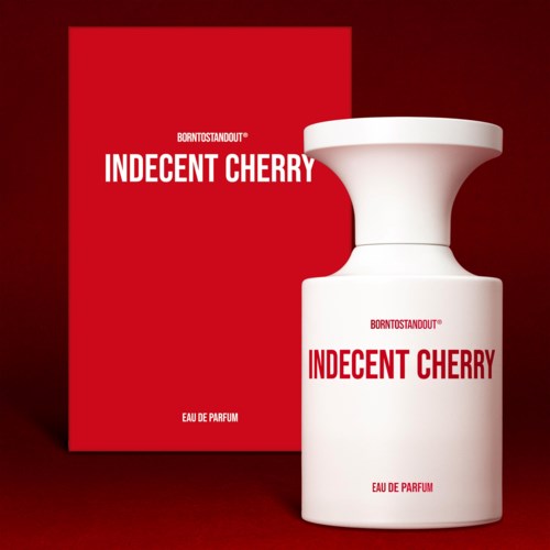 Punainen laatikko mainostaa 'Indecent Cherry'-hajuveden valkoisella pullolla. Yksinkertainen, rohkea teksti. Tyylikäs ja minimalistinen muotoilu.