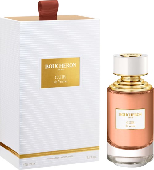 En parfyllflaska och box med gulddetaljer och ett röd bandhandtag. Etiketten säger Boucheron Cuir de Venise.