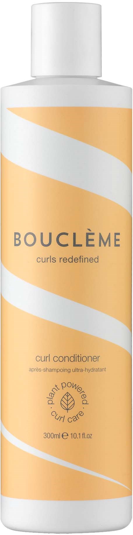 En lang hvid flaske med orange og hvid snoet design, mærket Bouclème curl conditioner.
