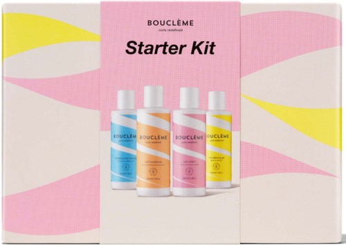 Vier Flaschen des Bouclème Starter Kits mit bunten Etiketten auf rosa-weißen Hintergrund.