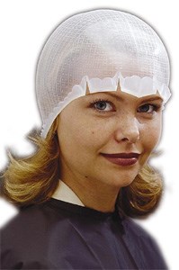 Eine Frau trägt eine weiße Haube und schwarzen Mantel, lächelt leicht, mit Haaren unter der Haube.