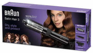 En hårstylingapparatslåda med en kvinna som visar sitt långa, blanka, vågiga bruna hår. Boxen nämner Braun Satin Hair 3.