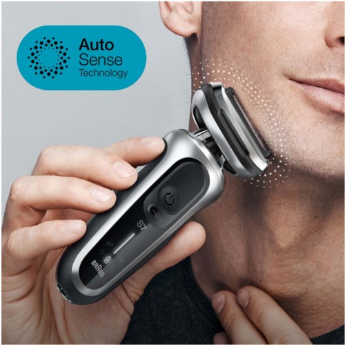 En mann barberer ansiktet med en elektrisk barbermaskin med Auto Sense Technology. Barbermaskinen er svart og sølvfarget.