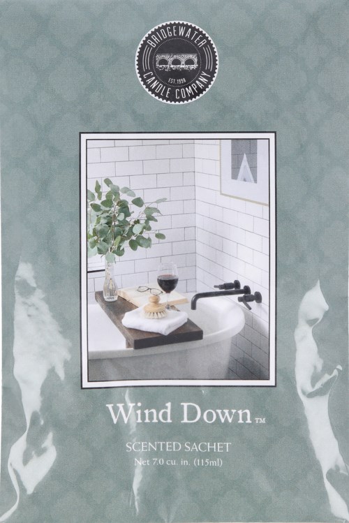 En doftpåse med bild av ett badkar, växt, vinglas och fönster. Produkten heter Wind Down.