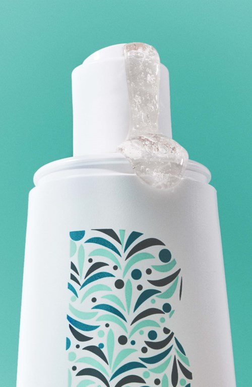 Eine weiße Flasche mit blauem und schwarzem dekorativem Muster und Gel, das herauskommt.