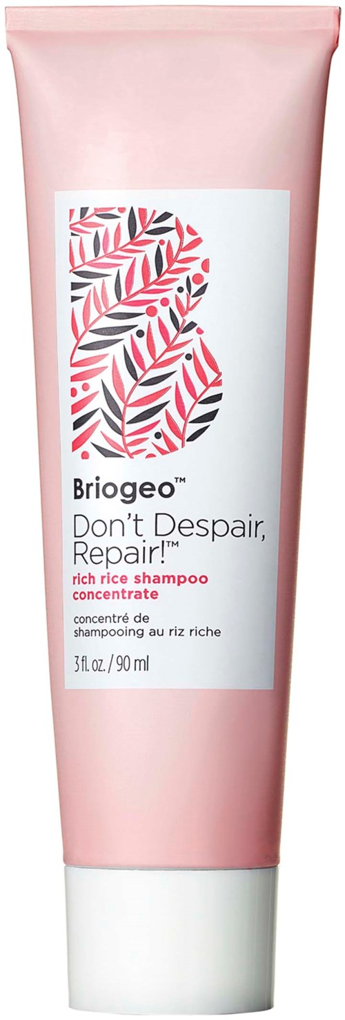 Pink tub med Briogeo-schampo med ett bladmönster och produktdetaljer på etiketten.