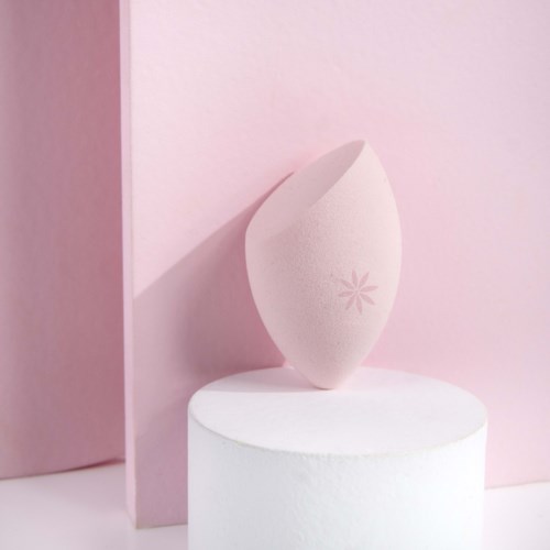 Ett vitt, runt föremål med en rosa blomdesign på, mot en rosa och vit bakgrund.