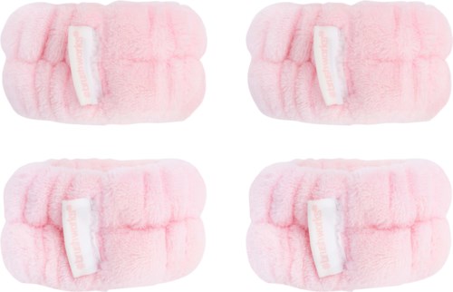 Fyra rosa fluffiga hårband med vita etiketter är placerade i ett 2x2 rutnät.