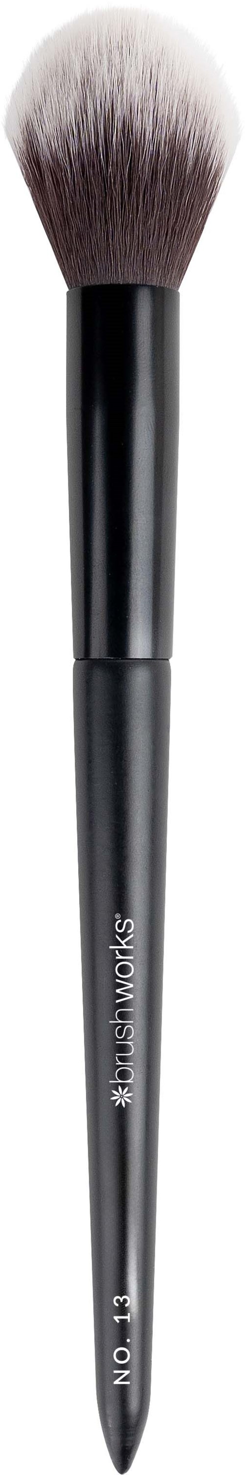En makeupborste med svart handtag och mjuka, fluffiga borst, används för att applicera puder eller rouge.
