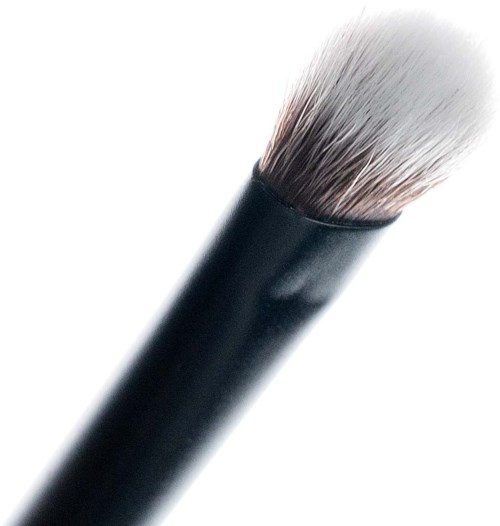 Närbild av en makeup-borste med svart skaft och vita borst.