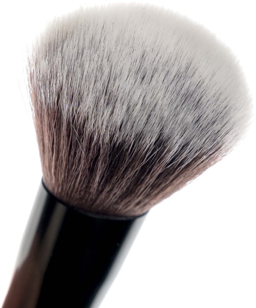 En makeupborste med mjuka vita och grå borst och ett svart handtag.