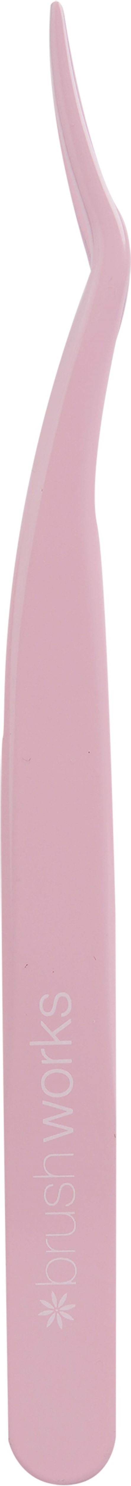 A pink toothbrush with a long handle and angled brush head, standing vertically. Text on the handle reads "small works."