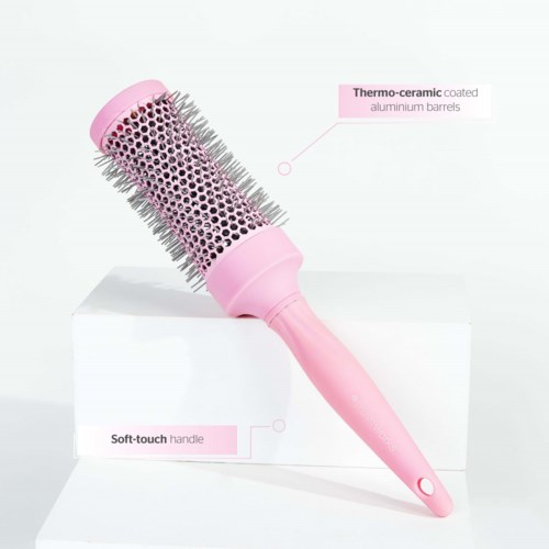 Een roze ronde haarborstel met metalen spelden, met een thermo-keramisch gecoat lichaam en een zachte handgreep.