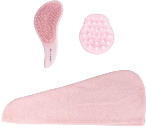 Sett med rosa børster og et mykt håndkle, sannsynligvis brukt til hudpleie eller skjønnhetsrutiner.