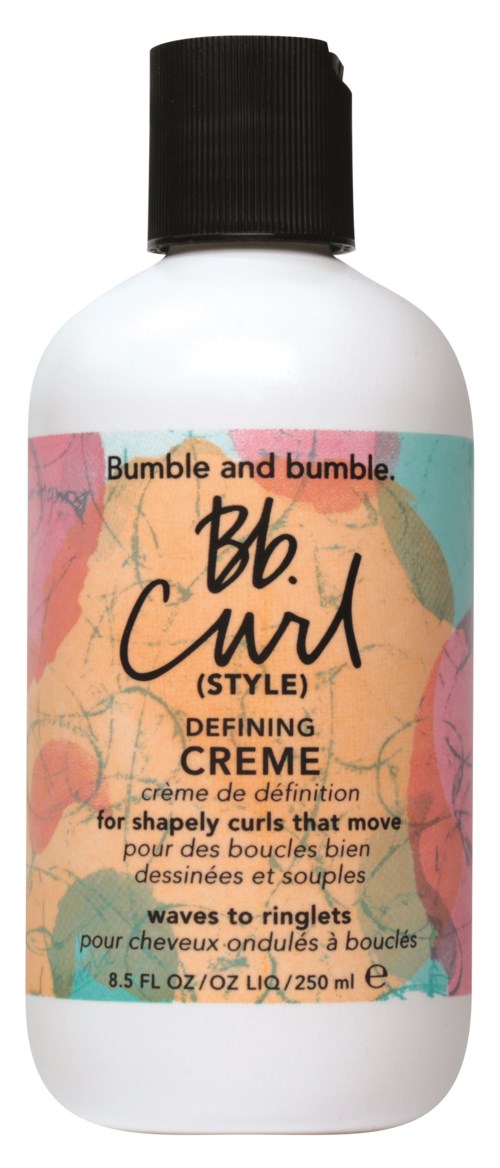 En vit flaska med svart lock, märkt Bumble and Bumble curl defining cream för stylade, vågiga lockar.