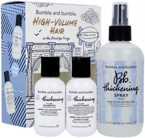 Ett box med tre hårvårdsflaskor och ett informationskort, med schampo, balsam och spray för voluminöst hår.