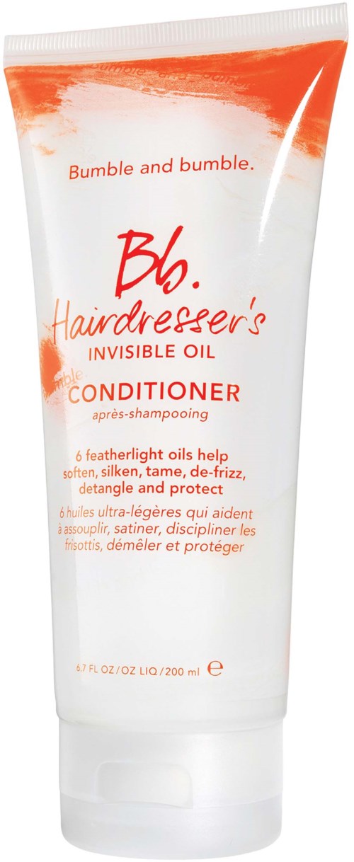 En vit tub med orange och röd text, märkt som balsam med fjäderlätta oljor, hjälper till att mjuka och skydda håret.