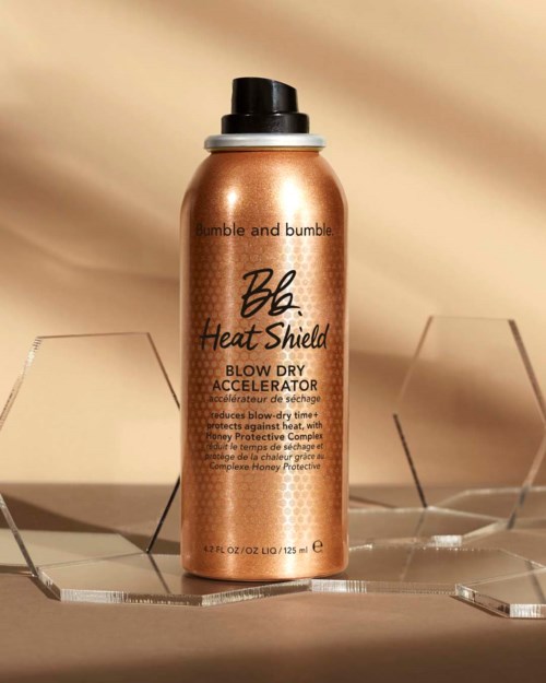 Guldfärgad sprayburk från Bumble and Bumble Heat Shield för locktorkning. Enkel att använda, skyddar håret mot värmeskador.