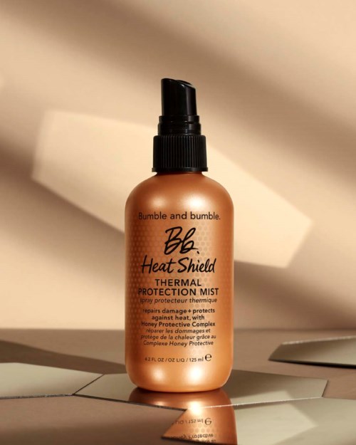 En brun sprayflaske med svart hette merket 'Bumble and bumble Heat Shield Thermal Protection Mist'.