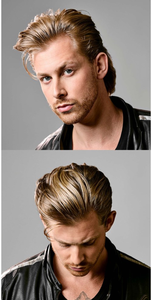 Twee mannen met gestyled blond haar dragen zwarte leren jassen en poseren tegen een grijze achtergrond.