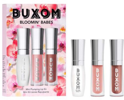 A mini lip plumping kit with three small bottles, displayed on a pink floral background. The brand name is BUXOM.