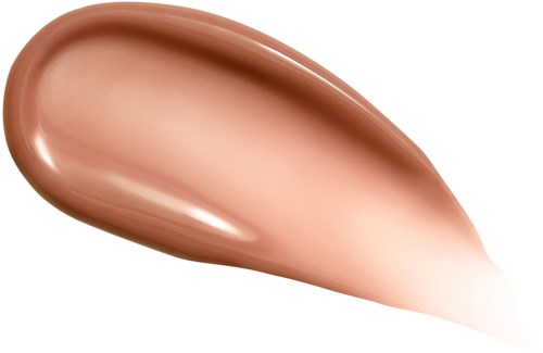 En slät, persikofärgad makeupgrund eller concealer på svart bakgrund.
