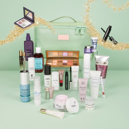 En mintgrön väska omgiven av olika hud- och makeupprodukter, med gulddekorationer och en spegel.