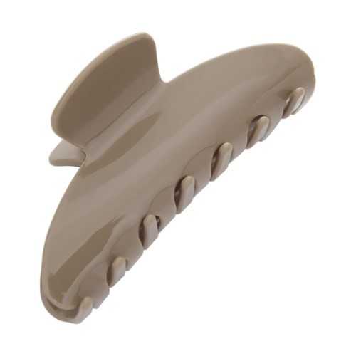 A beige hair clip with curved teeth and a rounded top.
