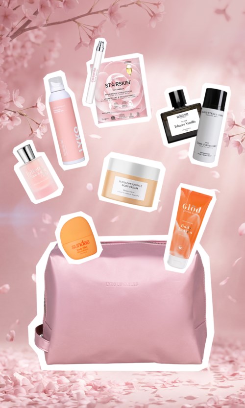 Beauty products, a pink bag, and cherry blossom background with soft pink tones.