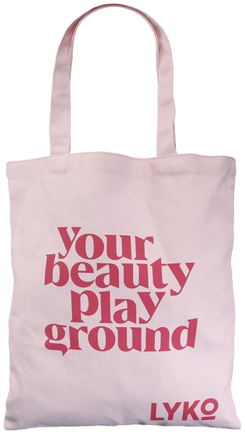 En lys pink stofpose med teksten 'Your beauty playground' og 'LYKO' trykt i fed pink skrift.