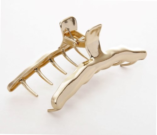 A gold hair clip shaped like a claw with multiple prongs.