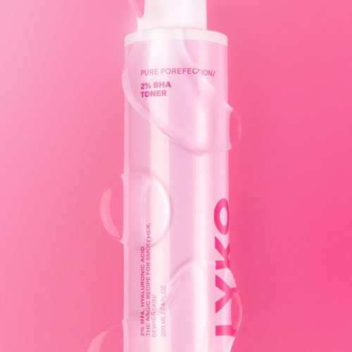 A pink skincare bottle labeled 'Pure Porefection' and '2% BHA Toner' with a pink background.
