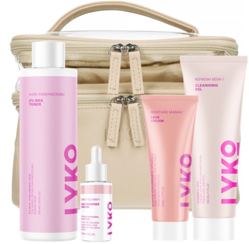 A beige bag with four pink skincare products placed in front of it, including bottles and tubes.
