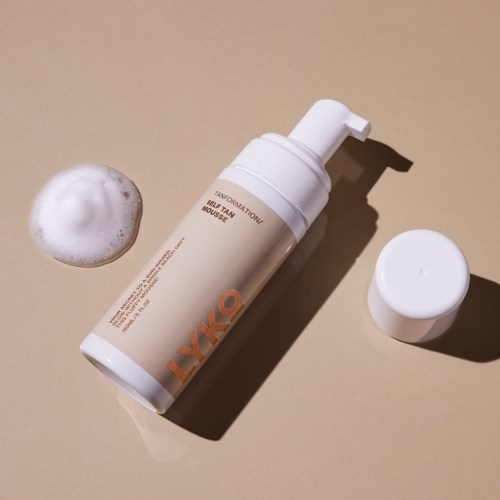 A skincare bottle labeled 'EXFOLIATING SEAL FORMULA' with foam and a white cap on a beige background.