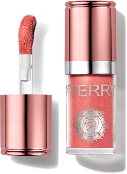 A pink lip gloss tube with a rose illustration on the label and its applicator wand nearby.