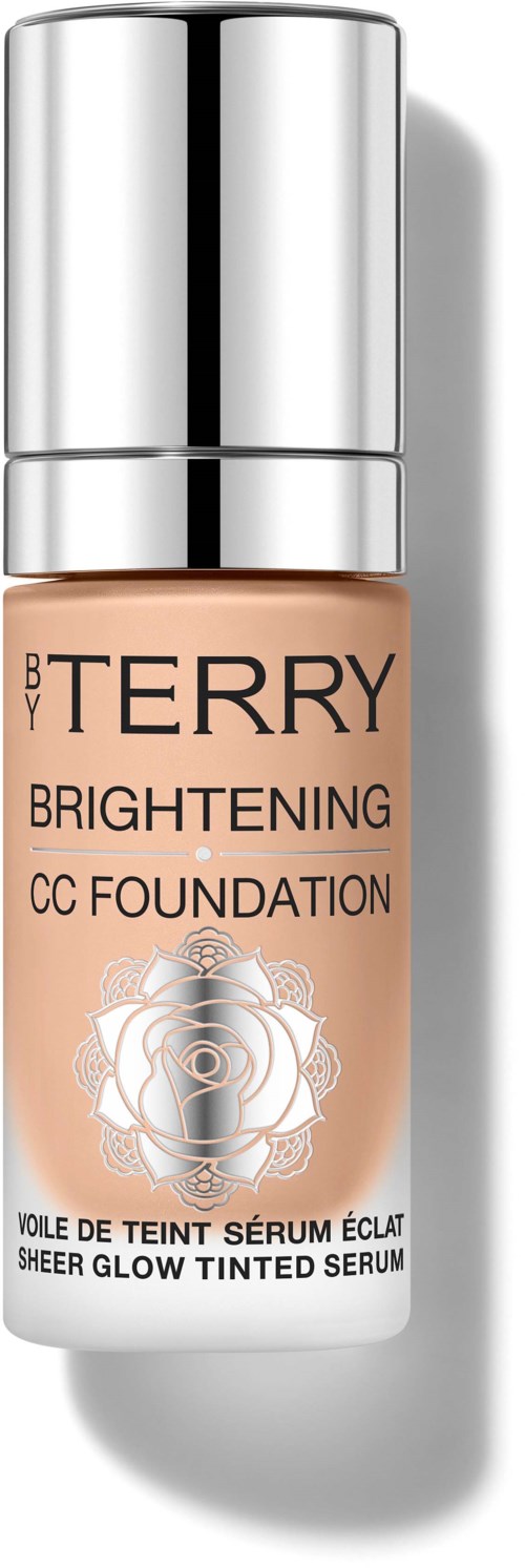 En flaske med BY TERRY Brightening CC Foundation med sølvsopp og ferskenfarget væske inni.