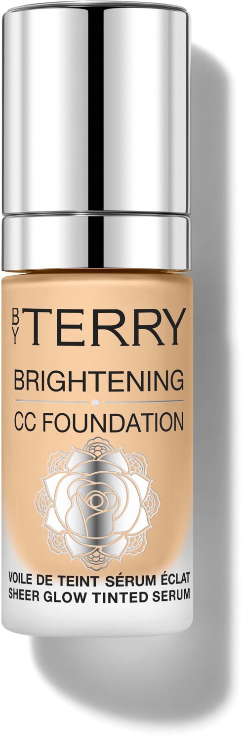 En flaske BY TERRY Brightening CC Foundation med en sølvhette og en rose logo på etiketten.