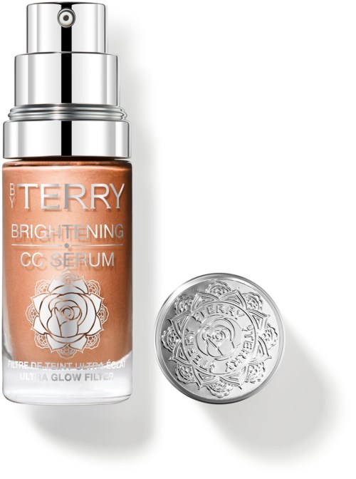 En hudpleieserum flaske merket By Terry Brightening CC Serum, med en sølvhette og en dekorativ sølvbeholder.