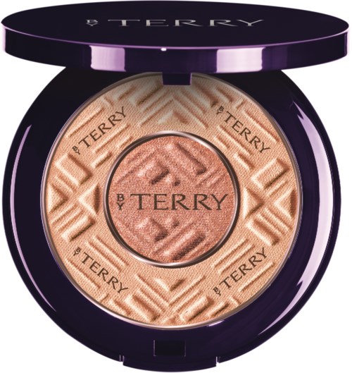 A round makeup compact with a purple lid, containing peach-colored pressed powder with 'By Terry' embossed designs.