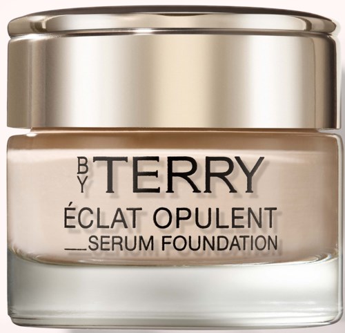 En lille glasbeholder med guld låg, mærket 'Terry Éclat Opulent Serum Foundation'.
