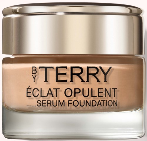 A jar of By Terry Éclat Opulent serum foundation in a glass container with a metallic lid.