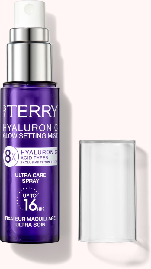 A purple facial spray with a silver cap and a clear cap next to it, labeled as hyaluronic glow setting mist.