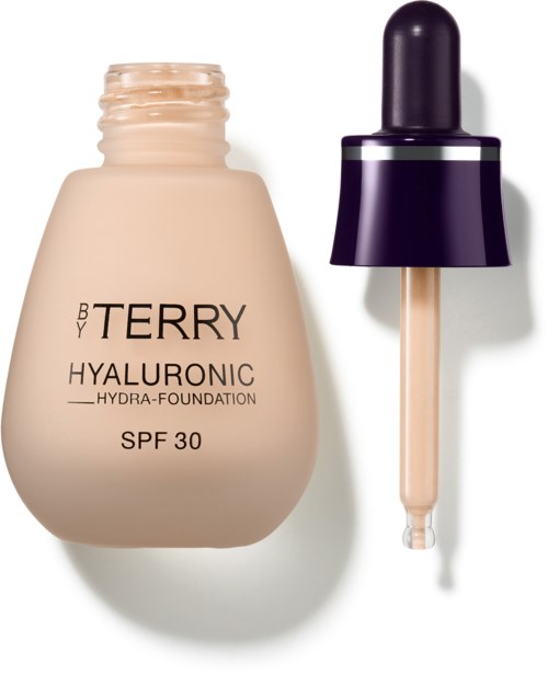 A beige bottle of BB Terry Hyaluronic Hydro-Foundation with a black dropper cap beside it.