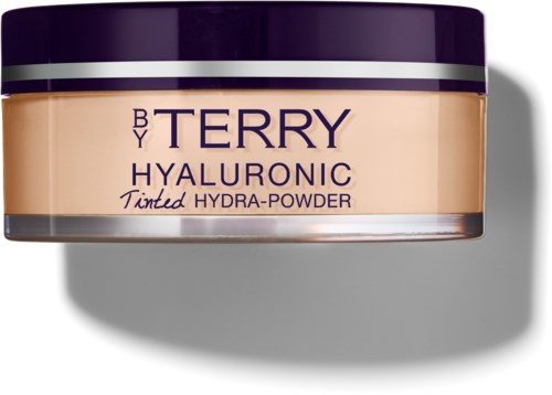 Ett glas med Tinted Hydra-Powder från Terry Hyaluronic, med lila och beige förpackning, placerad på en yta.