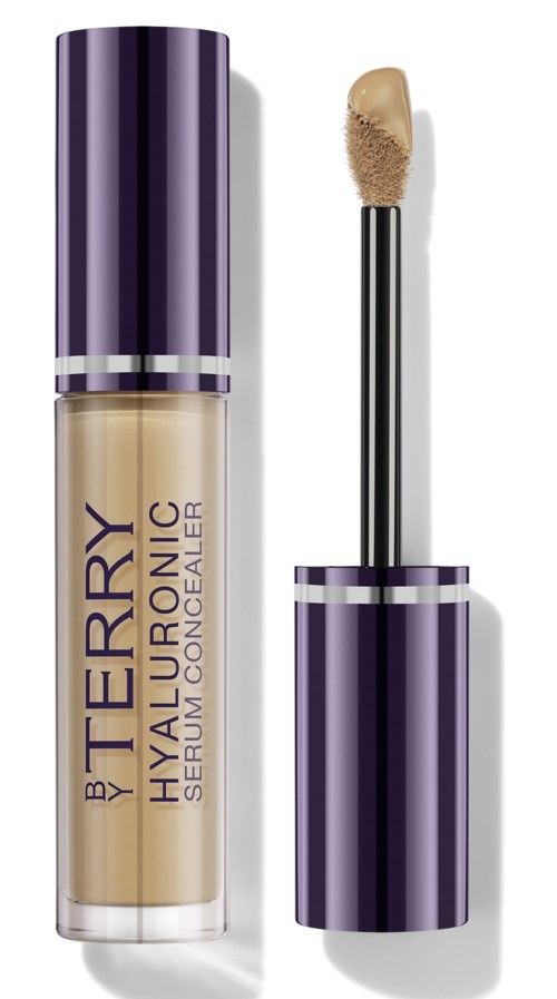 A beige concealer in a bottle with a purple cap. The wand applicator is next to the bottle.