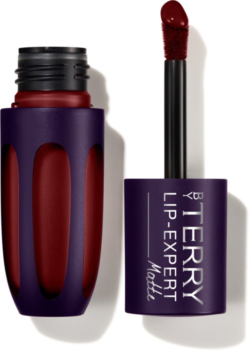A lipstick with dark red color, in a purple container, and a black and purple cap. It is open, showing the lipstick.